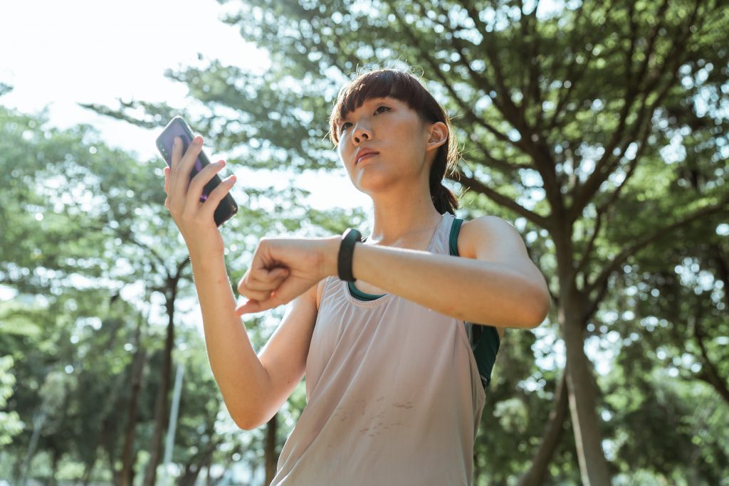 woman with a phone and Fitbit