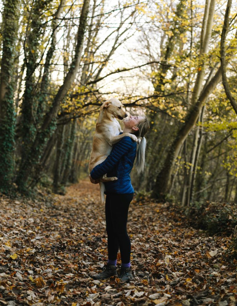woman with dog outdoors in woods