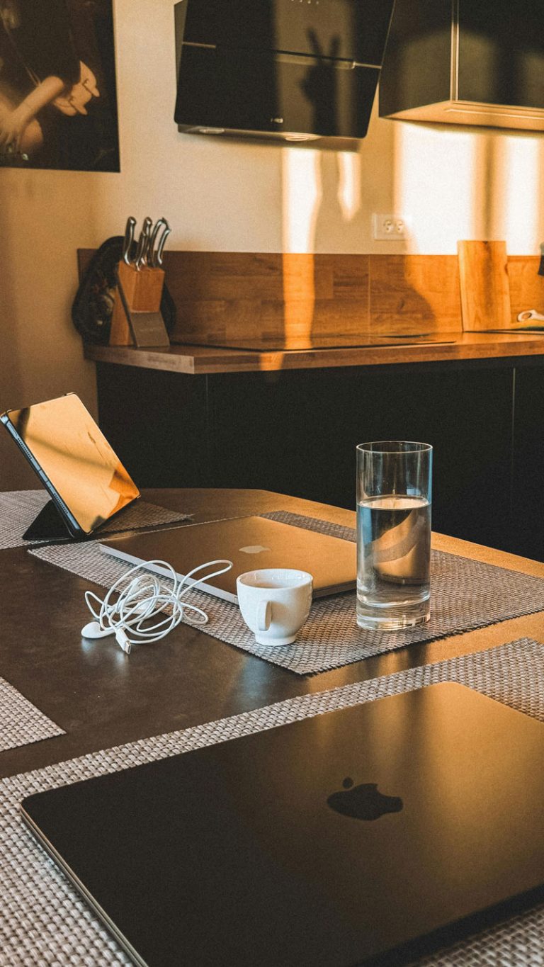 laptop, headphones and water on kitchen table