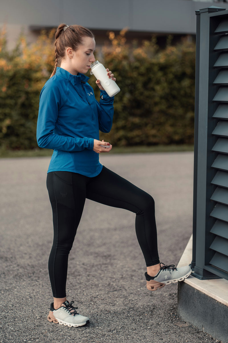 girl in workout gear having a drink