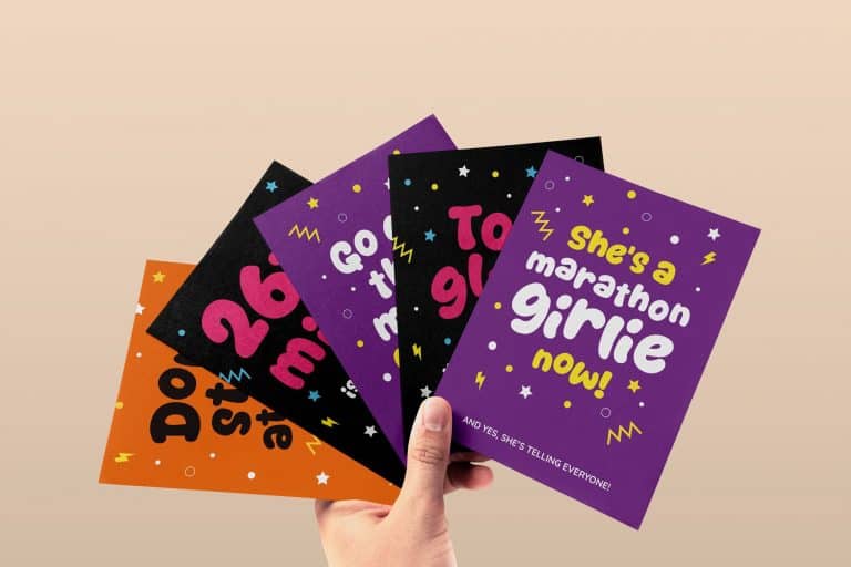 A collection of colourful, fun running-themed greeting cards displayed on a flat lay. Designs include bold, playful phrases like 'Go get that medal queen' and '26.2 miles is basically just four 10Ks and a bit #girlmath' – perfect for young female runners