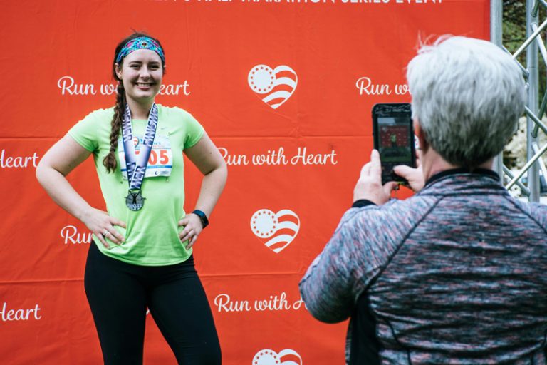 young woman posing with a marathon medal