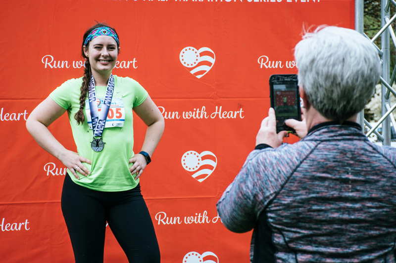 young woman posing with a marathon medal